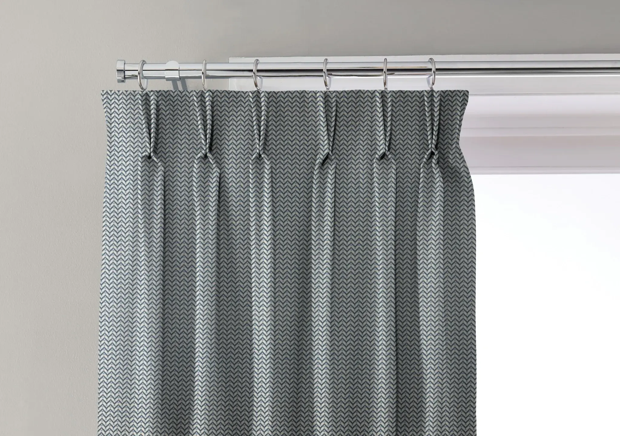 Curtain with a double pinch pleat heading fitted to rings on a pole