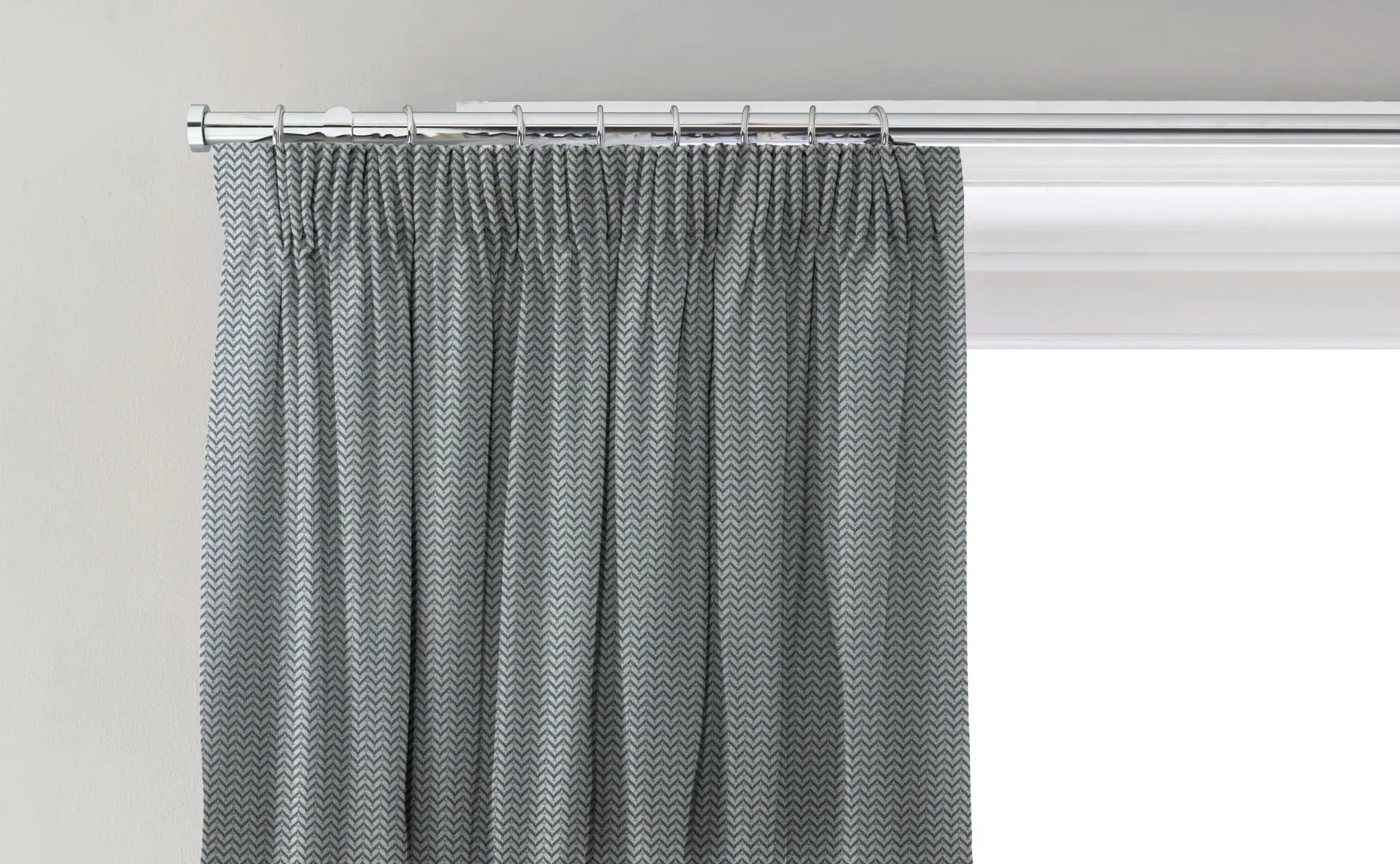 Curtain with a pencil pleat heading fitted to rings on a pole