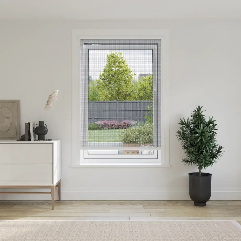 Roller insect screen lowered across a window overlooking a garden