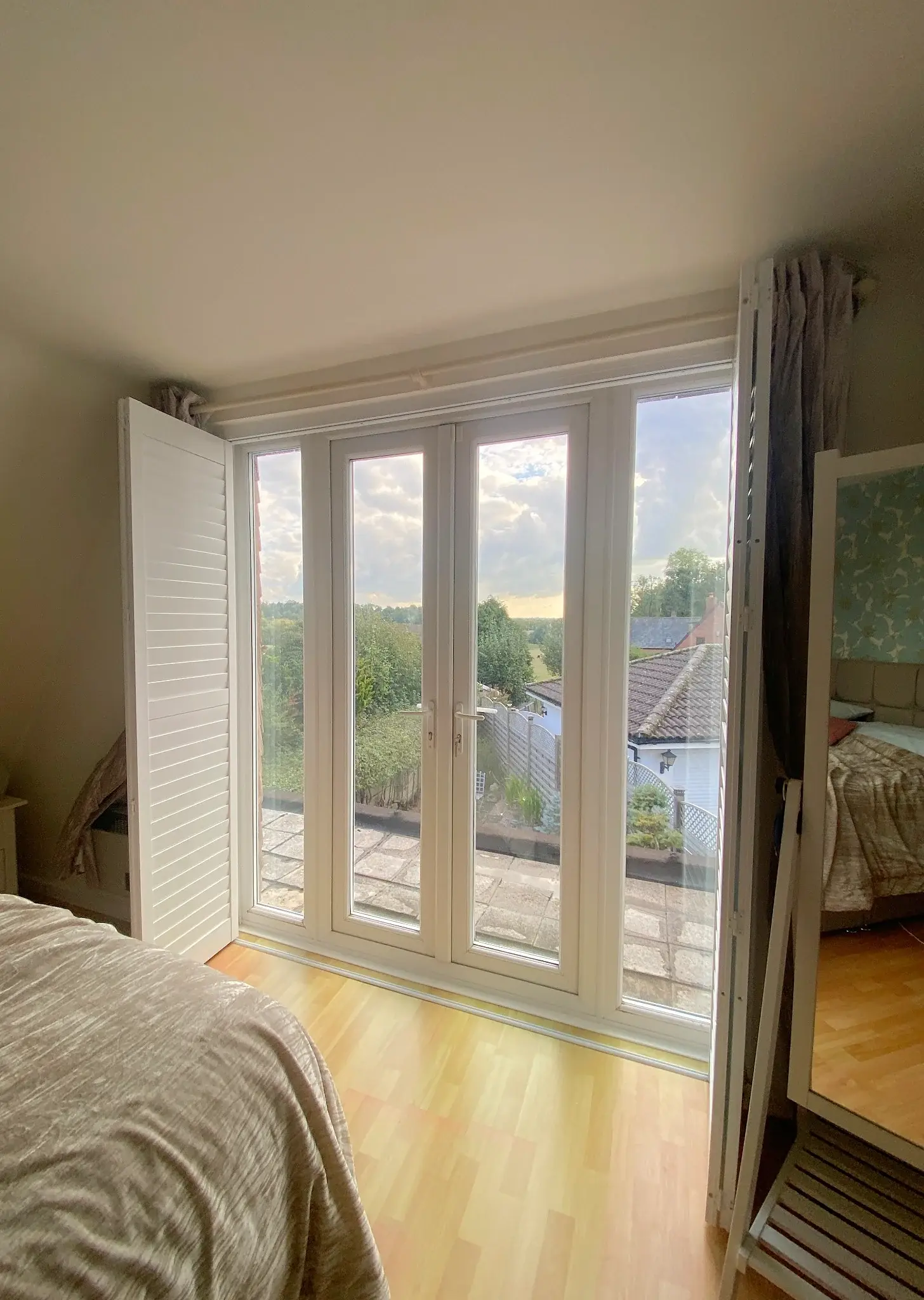 Pure White tracked shutter panels folded back to either side of the doors