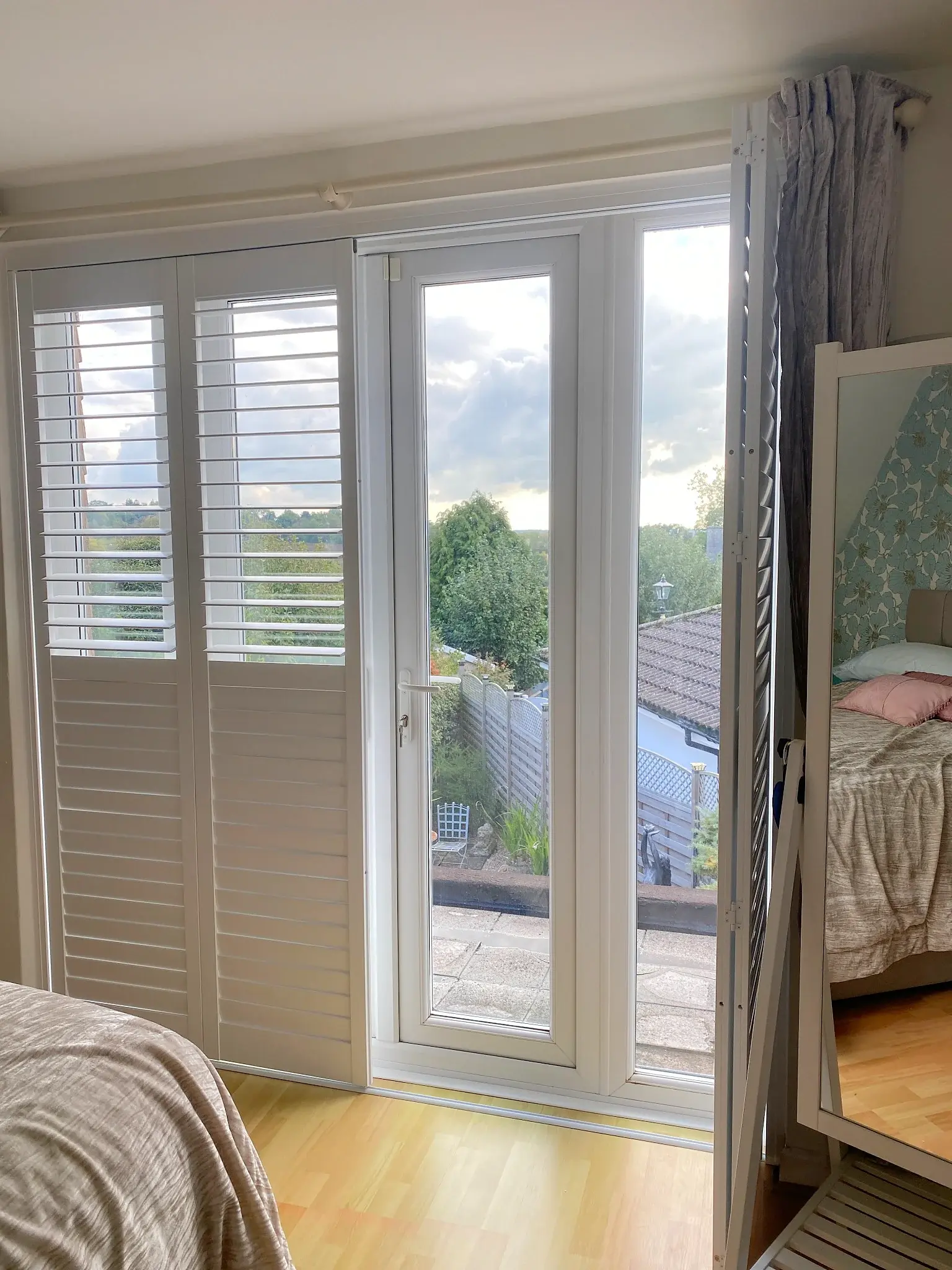 Tracked shutters with the right-hand panels folded back and the left-hand panels in place
