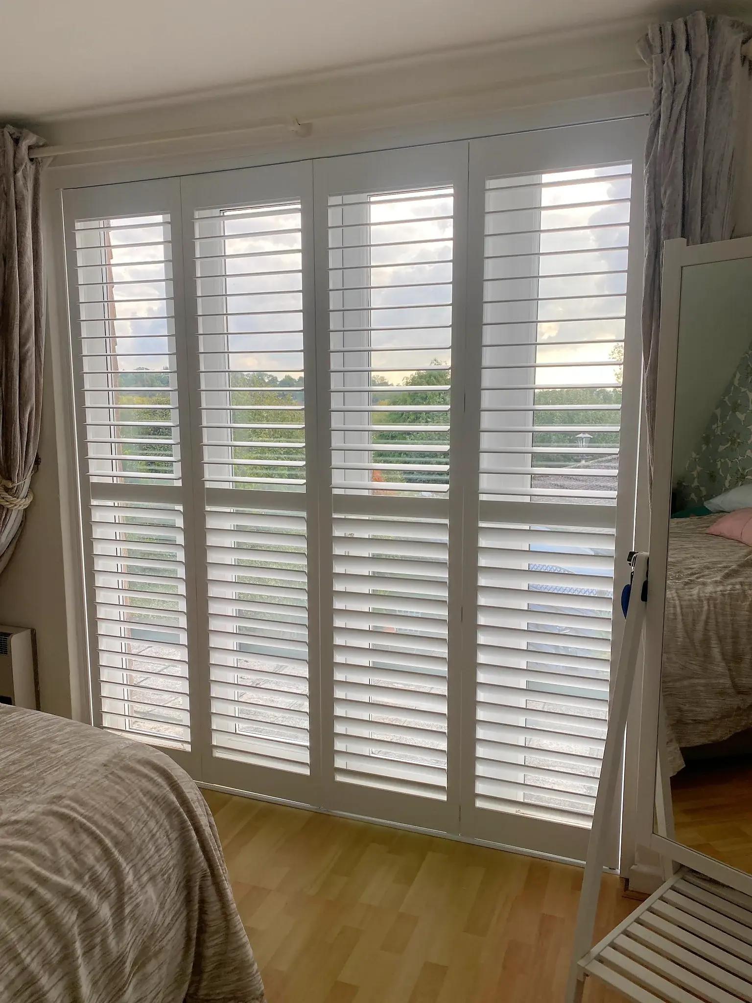 Pure White tracked shutters with 76 mm louvres across the glazed doors in Great Glen, Leicester