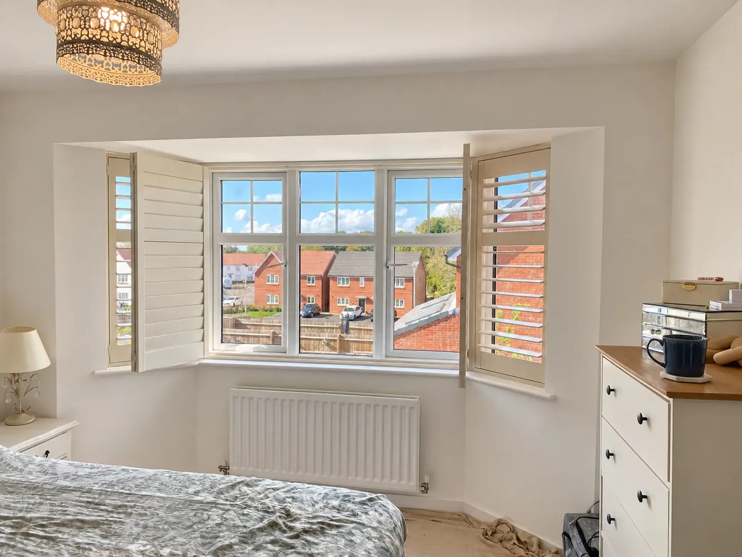 Bedroom bay shutter panels folded back to reveal the window glazing