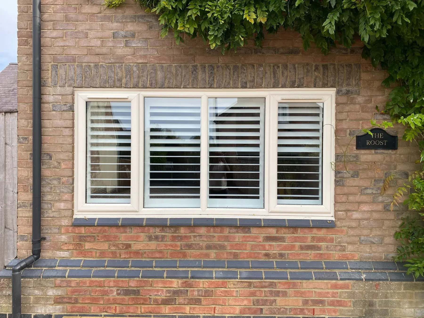 Matching Pure White wooden shutters at a smaller window on the same Lutterworth installation