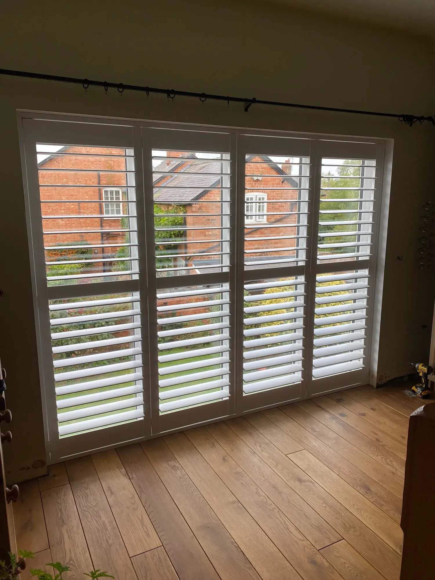 Paulownia wood shutters with the 89 mm louvres open at the tall upstairs window