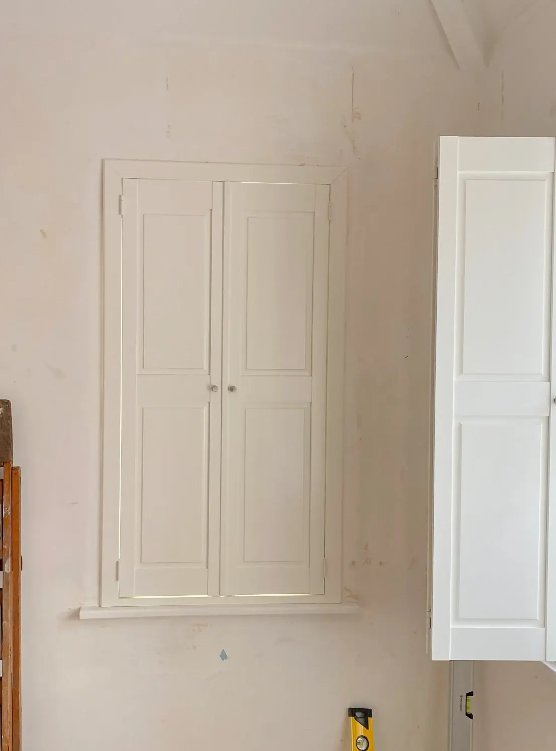 Closed Silk White solid panel shutters fitted to a narrow window