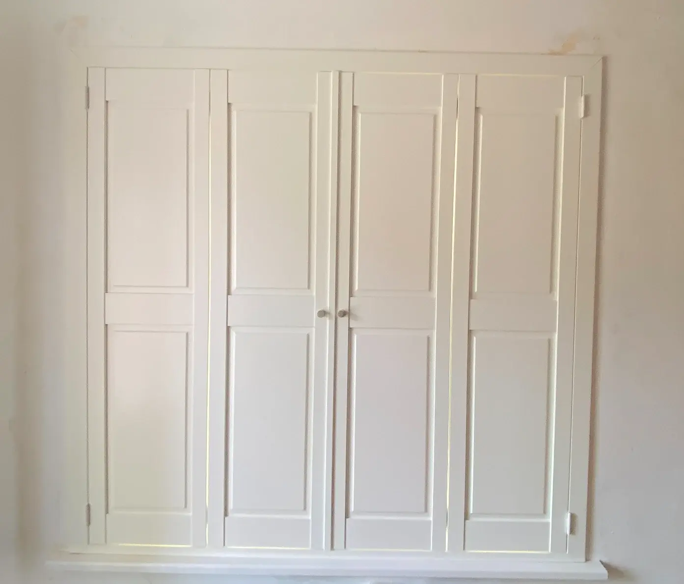 Silk White solid panel shutters closed across a window in Market Harborough