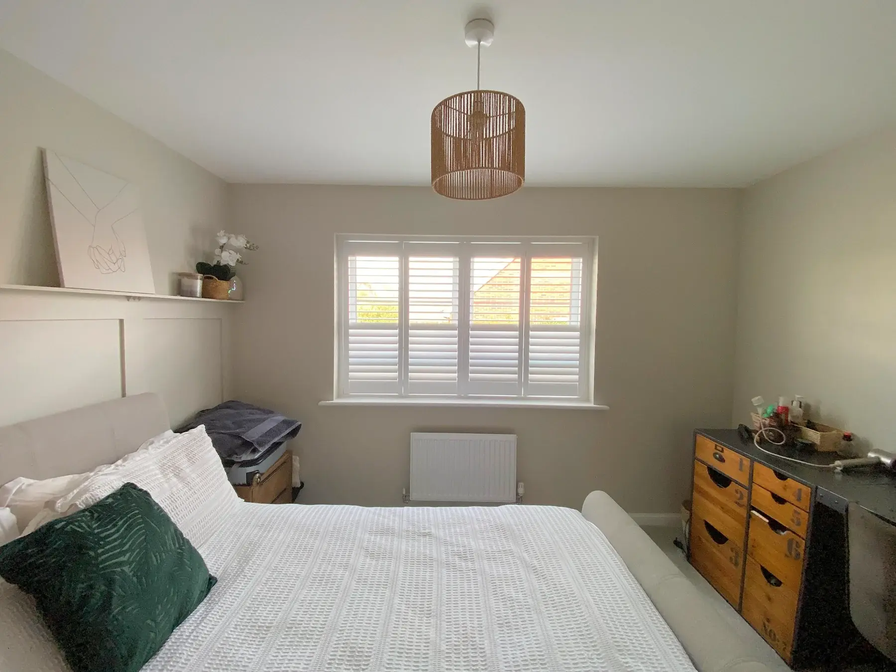 Full-height shutters with 63 mm louvres in Wellingborough: Full-height shutters within the bedroom setting.