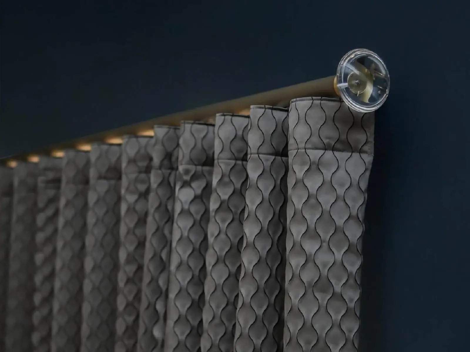 A premium curtain pole installation with a decorative acrylic finial and wave-style fabric folds