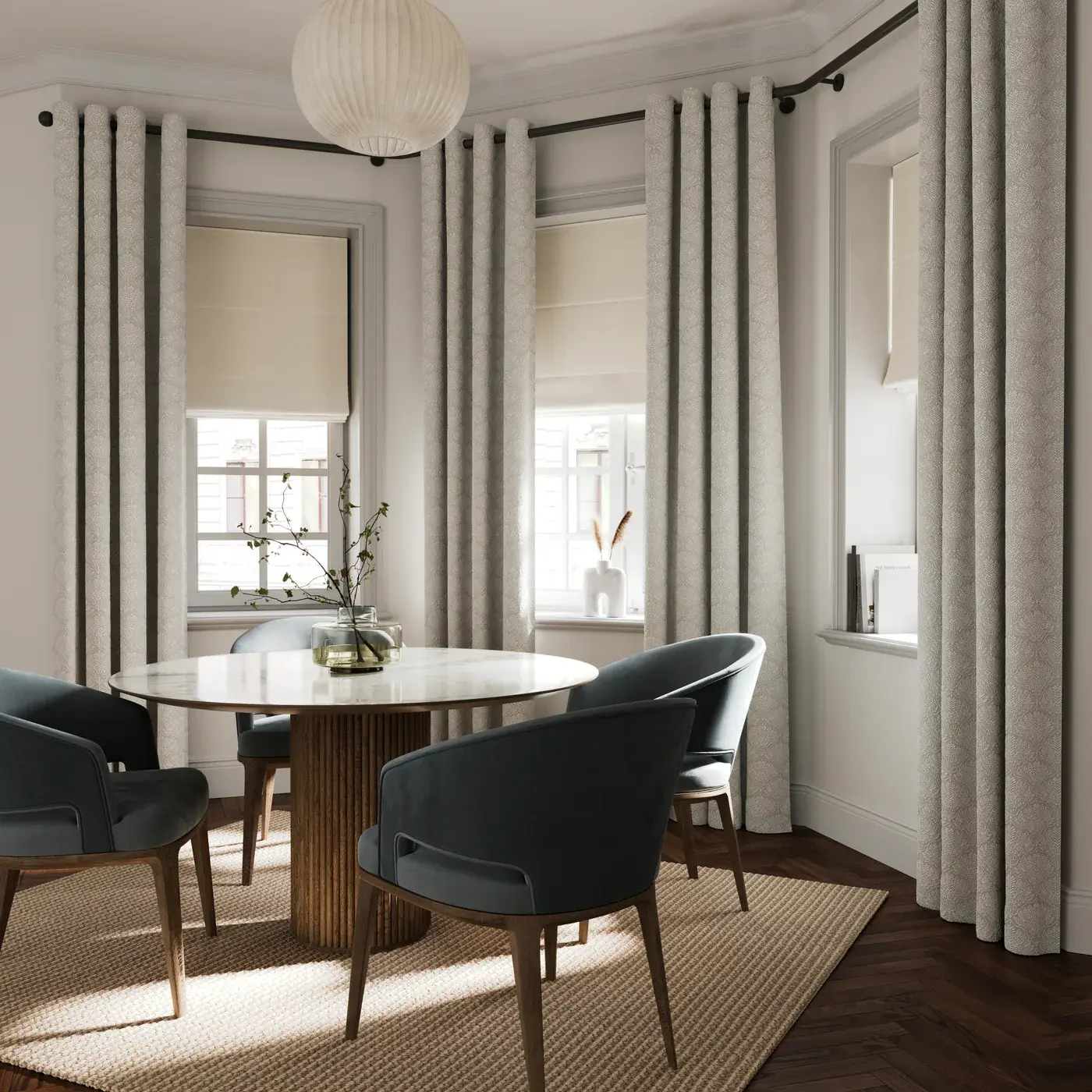 Roman blinds coordinated across three windows in a bay, paired with matching curtains