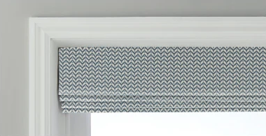 Grey herringbone Roman blind in Cascade fold, fitted to a window recess